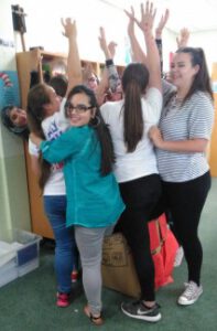 students try to fit as many of their classmates into the giant red box as they can