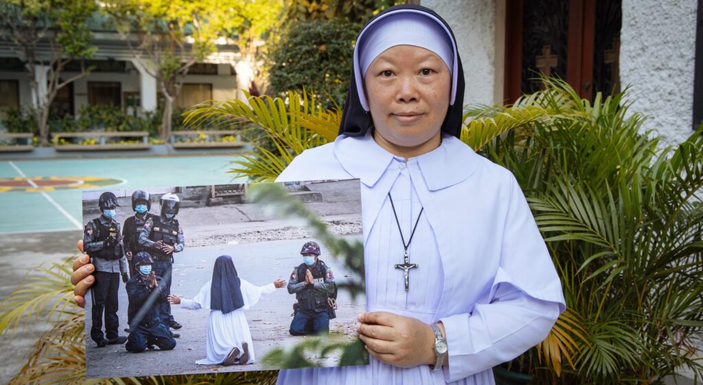 Sr Ann, holding a photograph of her kneeling in prayer before the Burmese military